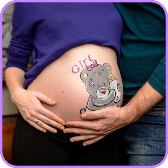 Belly painting of teddy bear for a baby girl – intimate pregnancy photo.
