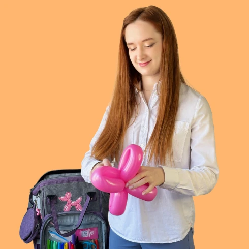 Artist making a pink balloon dog for a kidsâ party in Zurich