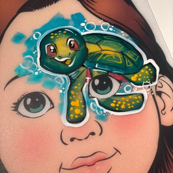 Face painting of a colorful sea turtle on a child's forehead