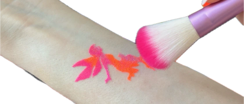 Pink glitter tattoo of a fairy on the skin