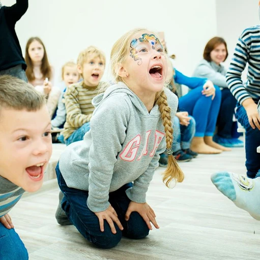 Children with face painting laughing during a corporate event