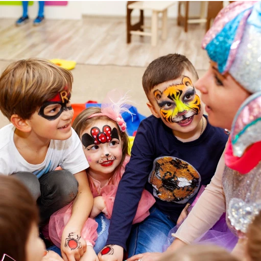 Children with colorful face painting listening to entertainer at a party
